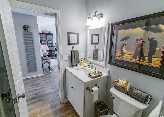 bathroom featuring vanity, wood finished floors, and toilet