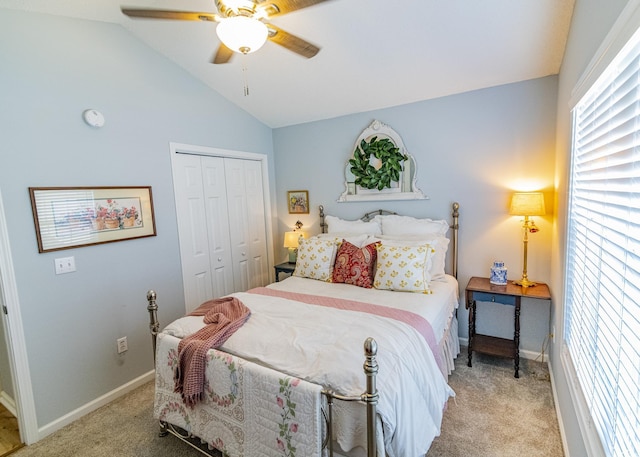 bedroom with lofted ceiling, a closet, light carpet, and baseboards