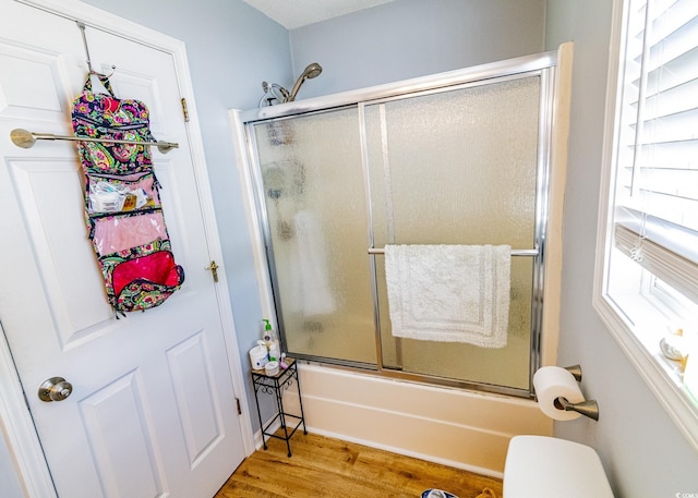 full bathroom with enclosed tub / shower combo and wood finished floors