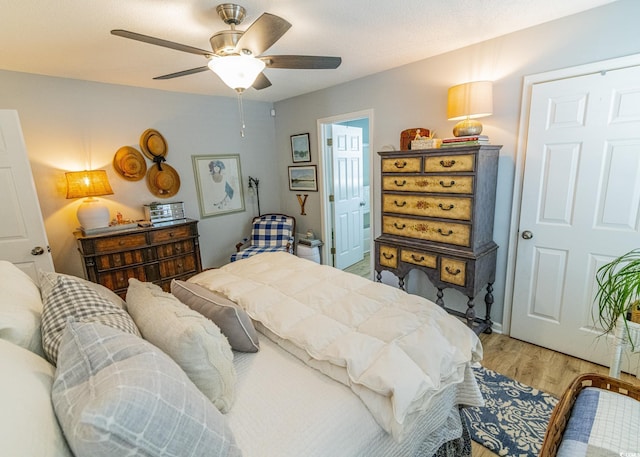 bedroom with a ceiling fan and light wood-type flooring