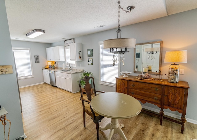 interior space featuring baseboards, light wood-type flooring, visible vents, and a healthy amount of sunlight