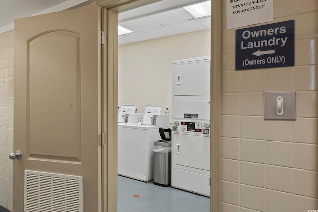 common laundry area with stacked washing maching and dryer and visible vents