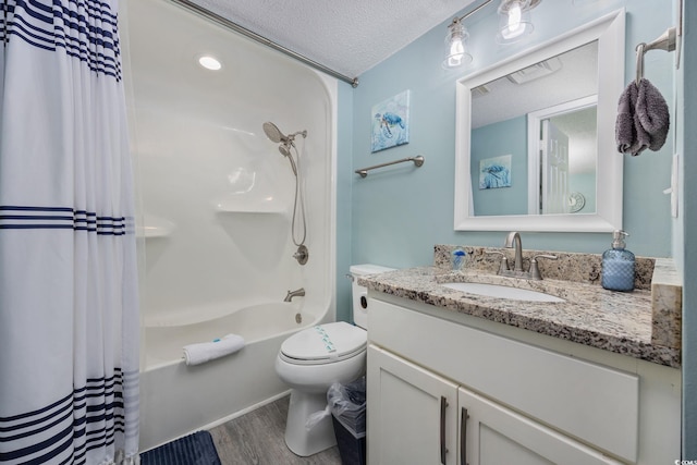 bathroom featuring toilet, shower / bath combo, vanity, a textured ceiling, and wood finished floors