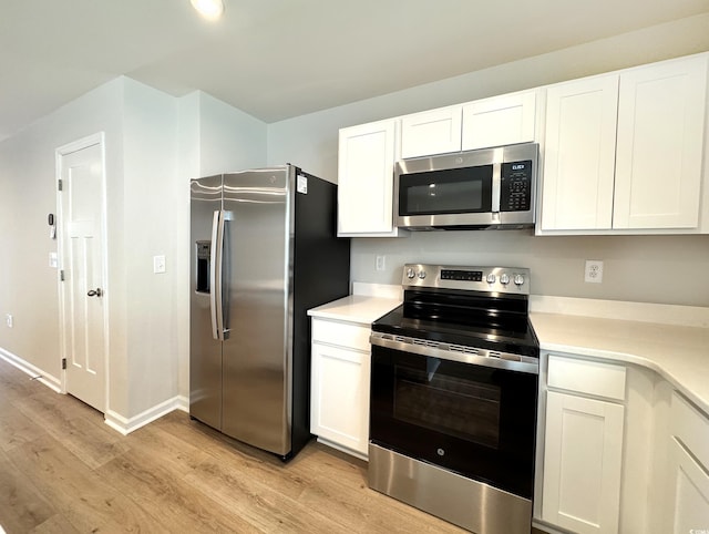 kitchen with baseboards, white cabinets, light countertops, appliances with stainless steel finishes, and light wood-type flooring