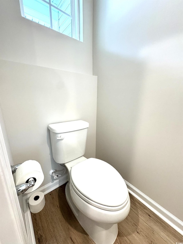 bathroom featuring toilet, baseboards, and wood finished floors