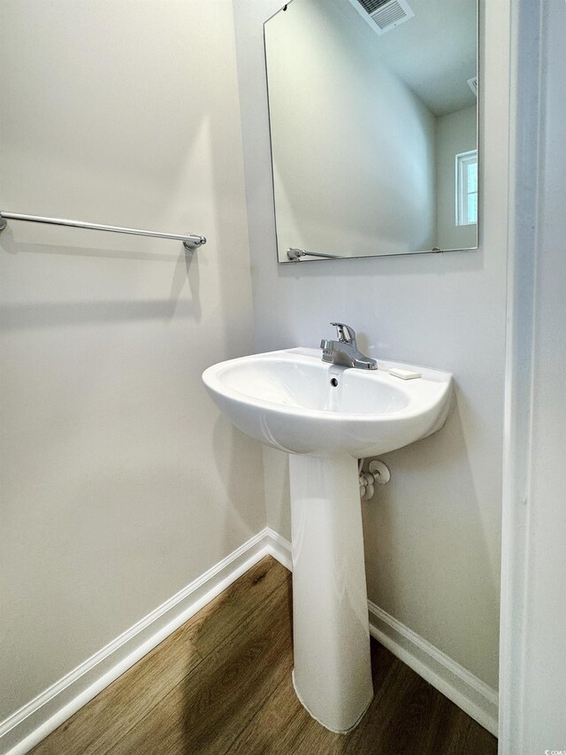 bathroom with visible vents, baseboards, and wood finished floors