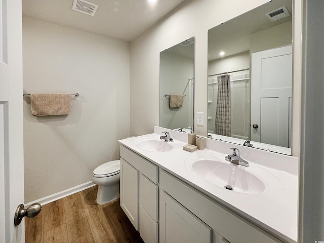 bathroom with visible vents, a sink, and wood finished floors