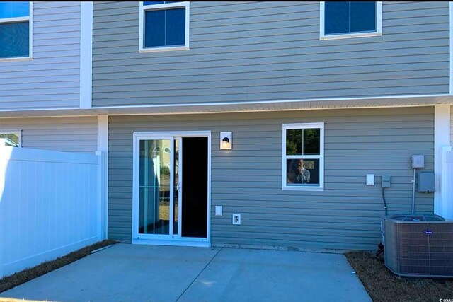 rear view of house featuring cooling unit, a patio area, and fence