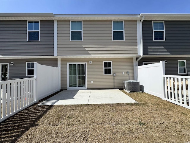 back of property with central AC unit, fence, and a patio