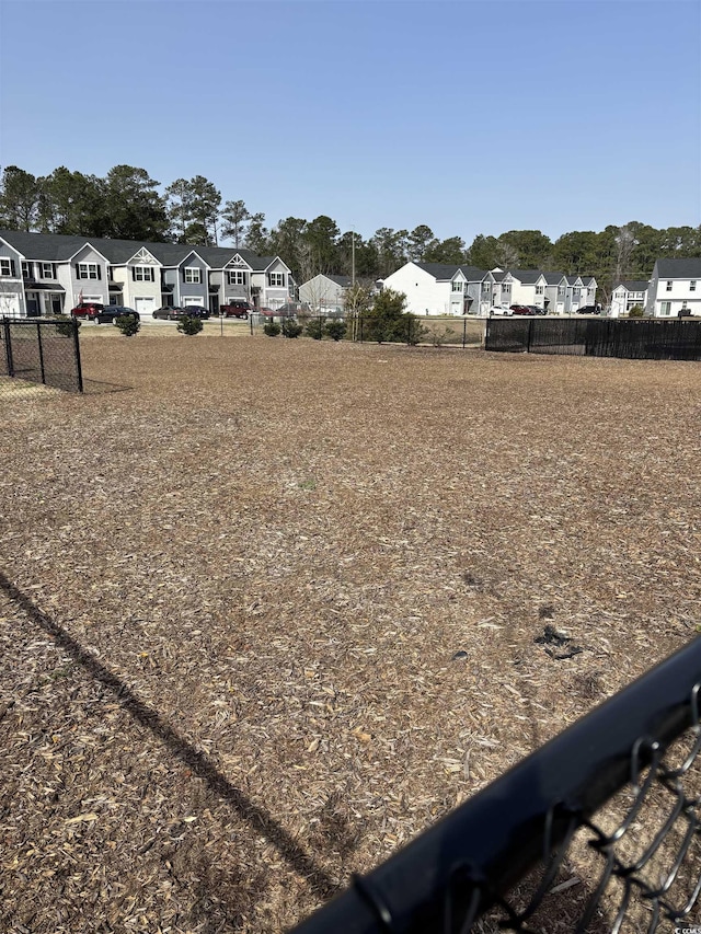 view of yard featuring fence and a residential view