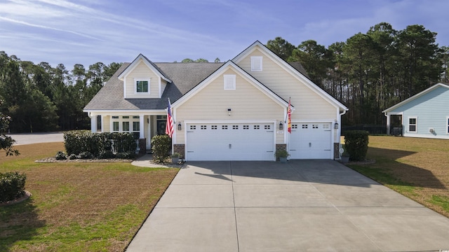 view of front of property with a front yard, concrete driveway, and a garage