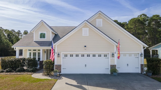 view of front facade with concrete driveway, a garage, and a shingled roof