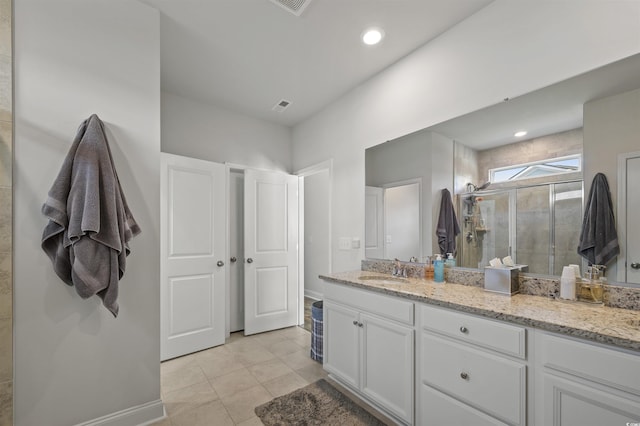 bathroom featuring vanity, visible vents, baseboards, a stall shower, and tile patterned flooring