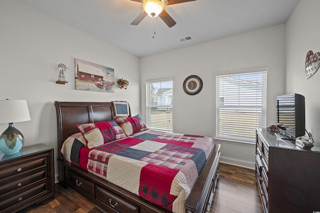 bedroom featuring dark wood finished floors, visible vents, a ceiling fan, and baseboards