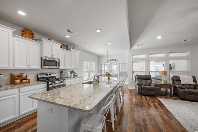 kitchen featuring a sink, appliances with stainless steel finishes, white cabinets, and dark wood finished floors