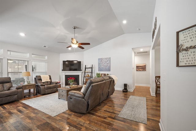 living room featuring visible vents, dark wood-type flooring, a fireplace, baseboards, and vaulted ceiling