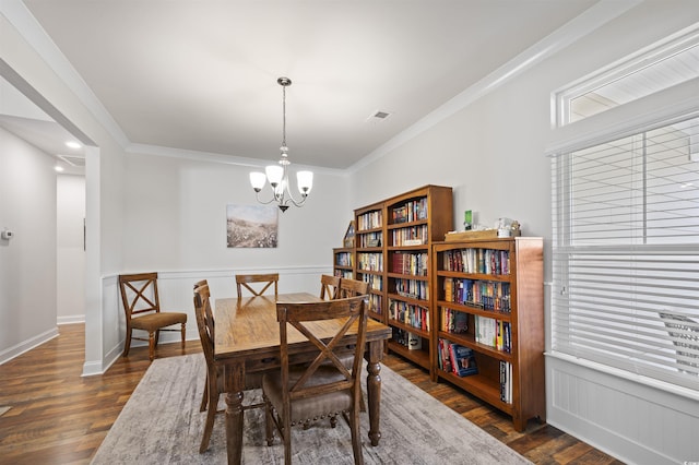 dining space with visible vents, crown molding, wainscoting, dark wood-style floors, and a notable chandelier