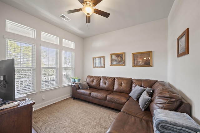 living area featuring visible vents, baseboards, and a ceiling fan