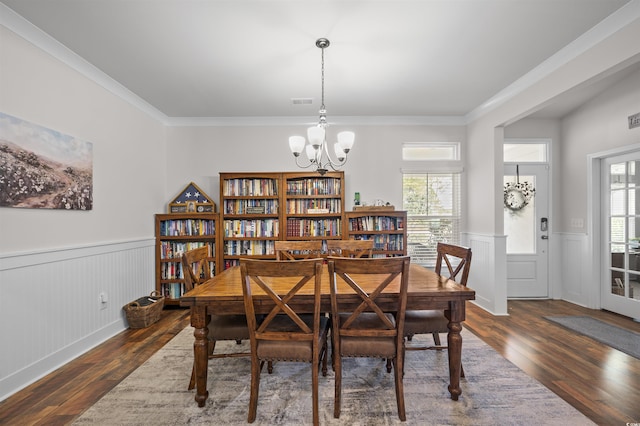 1201 Ficus Dr, Myrtle Beach, SC 29579 - dining area with a wainscoted wall, wood finished floors, a chandelier, plenty of natural light, and crown molding