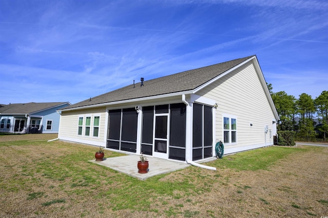 rear view of property with a patio, a lawn, and a sunroom