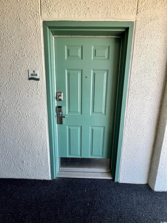 view of exterior entry with stucco siding