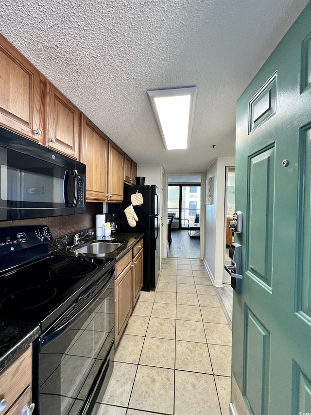 kitchen with light tile patterned floors, a sink, black appliances, dark countertops, and brown cabinets