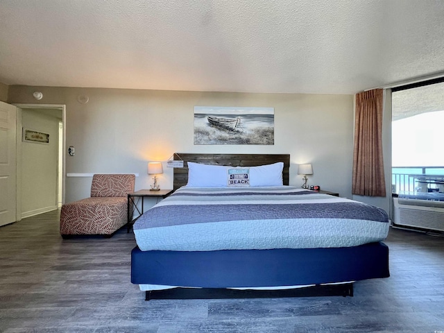 bedroom with a textured ceiling and wood finished floors