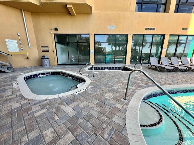 view of pool featuring a patio and an indoor in ground hot tub