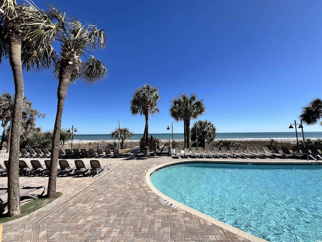 pool with a water view and a patio area