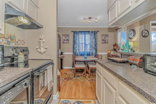 kitchen with light wood finished floors, ornamental molding, white cabinetry, under cabinet range hood, and black appliances