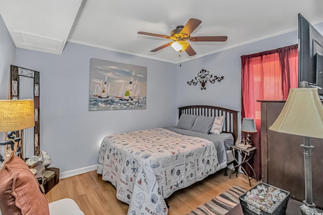 bedroom featuring ceiling fan, wood finished floors, attic access, and baseboards