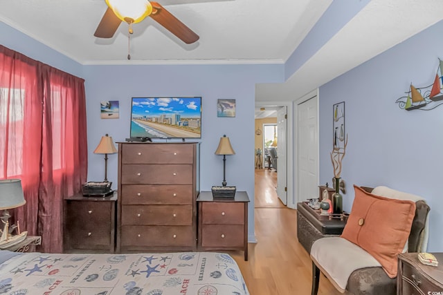 bedroom featuring crown molding, multiple windows, ceiling fan, and wood finished floors