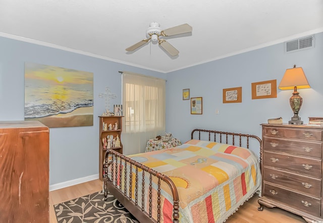 bedroom with crown molding, visible vents, ceiling fan, wood finished floors, and baseboards