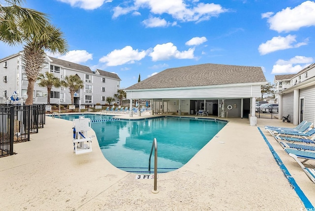 community pool featuring fence and a patio