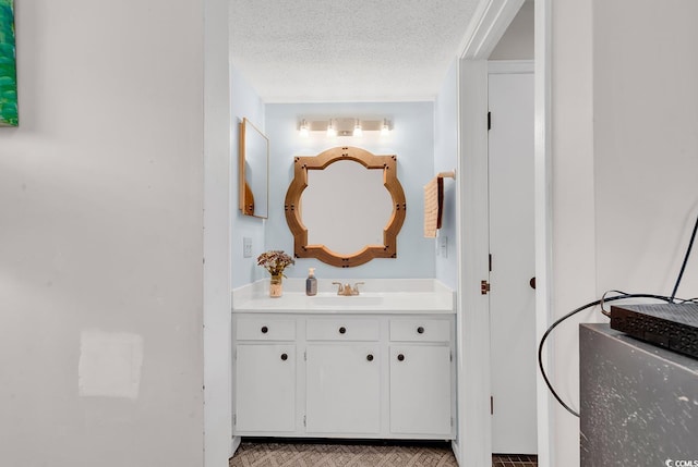 bathroom featuring a textured ceiling and vanity