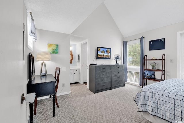 carpeted bedroom featuring ensuite bath, baseboards, and vaulted ceiling