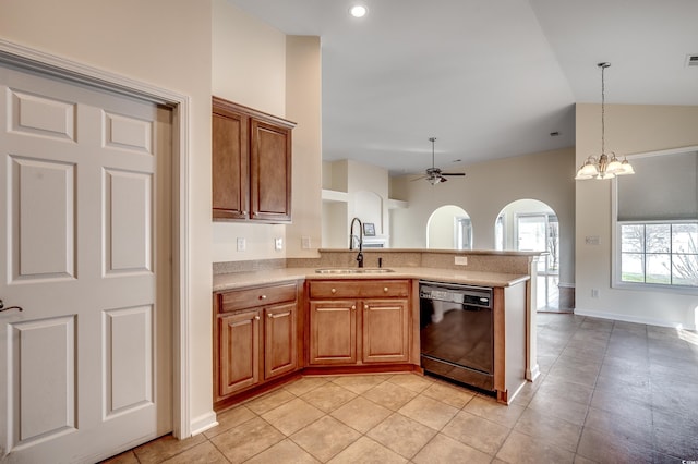 kitchen featuring brown cabinetry, dishwasher, vaulted ceiling, light countertops, and a sink