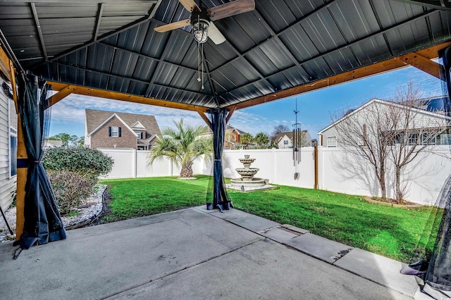 view of patio with a gazebo, a fenced backyard, and a ceiling fan