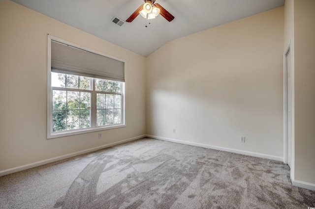 carpeted spare room featuring a ceiling fan, lofted ceiling, visible vents, and baseboards