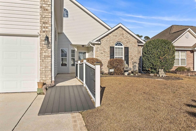 exterior space with a garage and brick siding