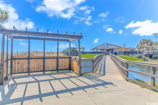 view of home's community featuring a water view and fence