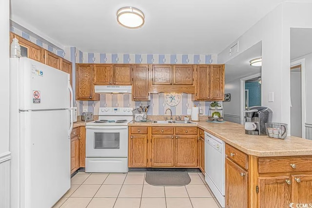 kitchen with under cabinet range hood, a peninsula, white appliances, a sink, and light countertops