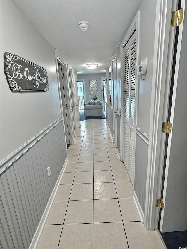 corridor with wainscoting and light tile patterned floors