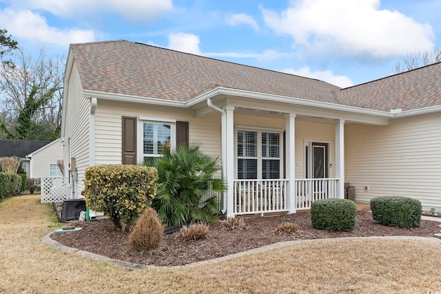 exterior space with a porch and roof with shingles