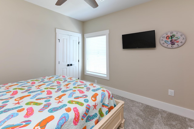 bedroom with a ceiling fan, baseboards, a closet, and carpet floors