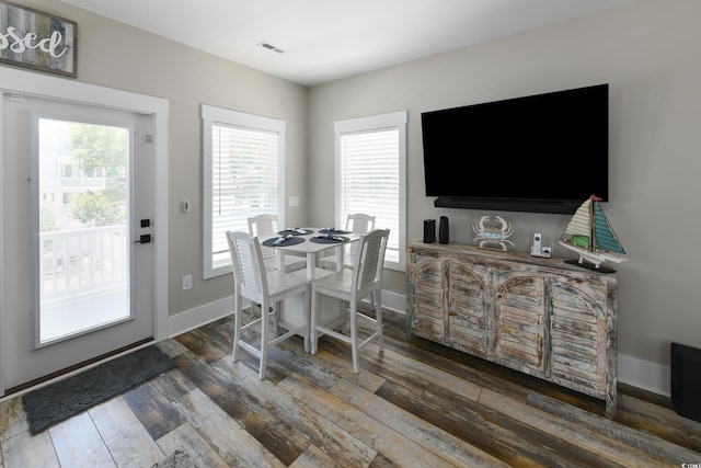 dining area featuring visible vents, baseboards, and wood finished floors