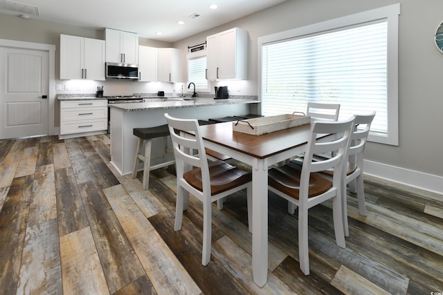 dining area with recessed lighting, baseboards, and dark wood-style flooring