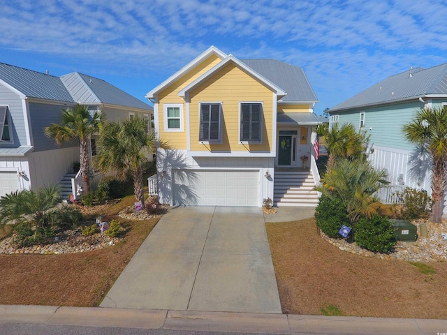 view of front of property with stairway, an attached garage, and driveway