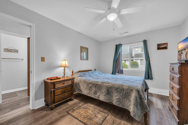 bedroom featuring visible vents, dark wood finished floors, a ceiling fan, and baseboards