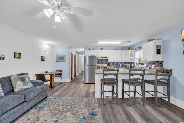 interior space featuring dark wood finished floors, a ceiling fan, and baseboards